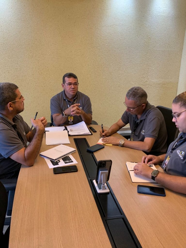 Foto da reunião de planejamento estratégico do Grupo Pinheiro com a presença de Marco Pinheiro, Thaynara, Cláudio, Max e Chrystian, discutindo ações de marketing e divulgação.